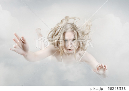 Young woman floating across the clouds in the sky. Young woman floating across the clouds in the sky. 66243538