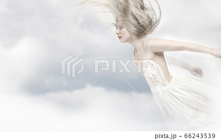 Young beautiful blonde girl flying in the clouds Young beautiful blonde girl flying in the clouds 66243539