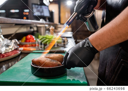 Using gas torch for cooking sweet potato 66243698