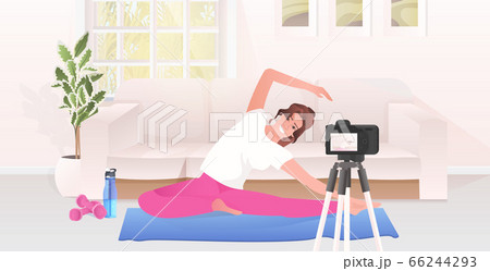 woman fitness trainer recording video blog using camera on tripod live streaming blogging workout concept 66244293
