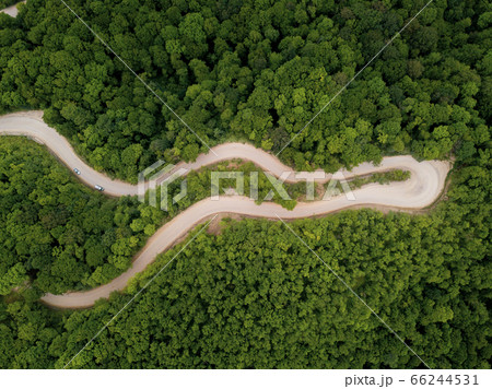 Mountain winding zig zag gravel road. Top aerial view: cars driving on road from above. Mountain winding zig zag gravel road. Top aerial view: cars driving on road from above. 66244531