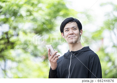 Bluetoothイヤホンを操作する男性 66244876