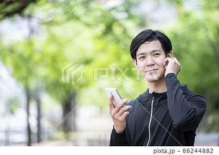 Bluetoothイヤホンを操作する男性 66244882