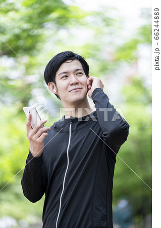 Bluetoothイヤホンを操作する男性 66244889