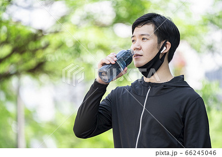 マスクをずらしてドリンクを飲む男性 66245046