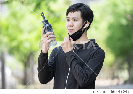 マスクをずらしてドリンクを飲む男性 66245047