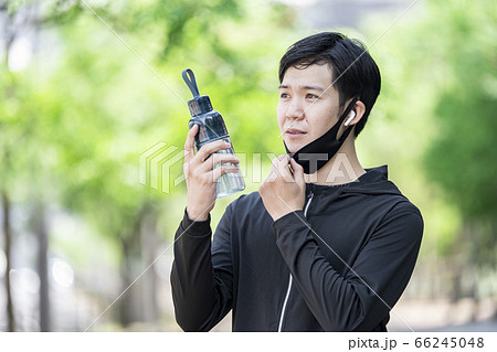 マスクをずらしてドリンクを飲む男性 66245048