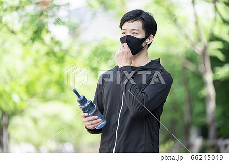 マスクをずらしてドリンクを飲む男性 66245049