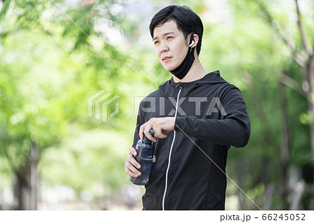 マスクをずらしてドリンクを飲む男性 66245052