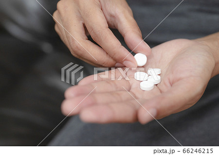 Close up of working woman taking in pill she is pours the pills out of the bottle,taking painkiller to reduce sharp ache concept,health care and medicine concept. Close up of working woman taking in pill she is pours the pills out of the bottle,taking painkiller to reduce sharp ache concept,health care and medicine concept. 66246215