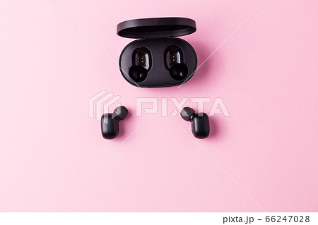 Close-up black wireless headphones on pink isolated background. Close-up black wireless headphones on pink isolated background. 66247028