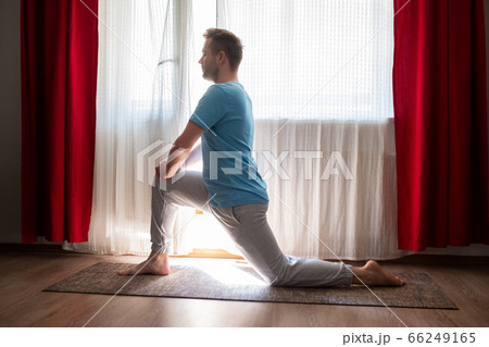 caucasian man in Anjaneyasana one leg lunge pose practicing online at home. caucasian man in Anjaneyasana one leg lunge pose practicing online at home. 66249165