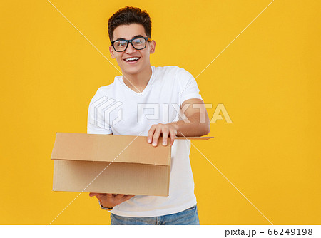 Astonished man looking inside carton box 66249198