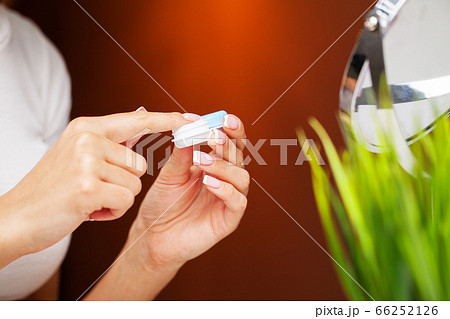 Woman removes contact lenses from a container with liquid Woman removes contact lenses from a container with liquid 66252126