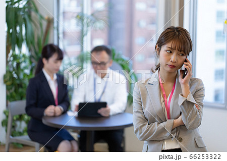打合せ中にスマホで連絡する女性社員 66253322