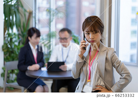 打合せ中にスマホで連絡する女性社員 打合せ中にスマホで連絡する女性社員 66253332
