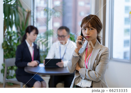 打合せ中にスマホで連絡する女性社員 66253335