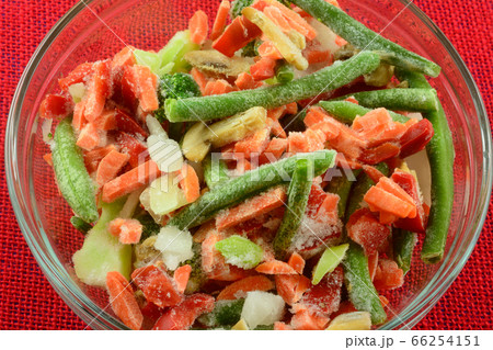 Frozen stir fry mixed vegetables of carrots, green beans, red bell peppers, carrots, onions and mushrooms in glass bowl 66254151