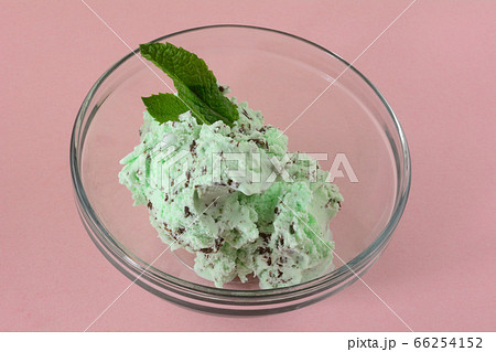 Mint chocolate chip ice cream in glass dessert bowl with fresh mint leaf garnish 66254152