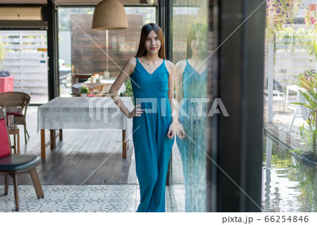 Young slim fit woman wearing green dress in front 66254846