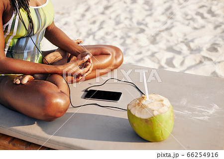 Woman in swimsuit listening to music Woman in swimsuit listening to music 66254916
