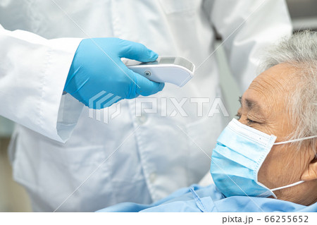 Doctor holding digital thermometer to measures asian senior or elderly old lady woman patient 66255652