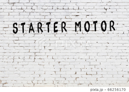 Word starter motor painted on white brick wall 66256170