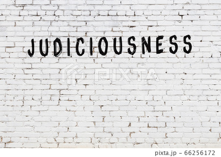 Word judiciousness painted on white brick wall 66256172