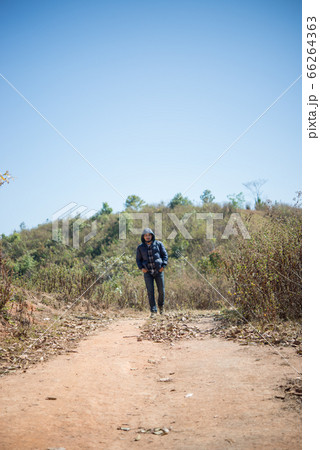 Hiker with backpack walking through forest Hiker with backpack walking through forest 66264363