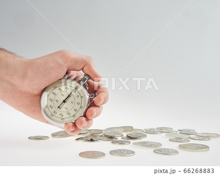 time is money. hand holding a stopwatch on a time is money. hand holding a stopwatch on a 66268883