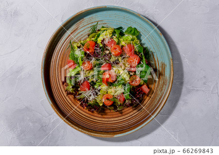 Salmon Salad. Salted salmon, mixed salad, grapefruit, Parmesan cheese, pine nuts in the dark plate Salmon Salad. Salted salmon, mixed salad, grapefruit, Parmesan cheese, pine nuts in the dark plate 66269843