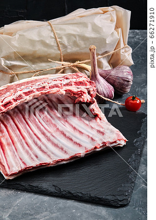 Lamb ribs fresh meat, with eco-friendly packaging. Food Delivery Concept. copy space, dark background Lamb ribs fresh meat, with eco-friendly packaging. Food Delivery Concept. copy space, dark background 66271910