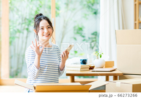 スマホを操作して引越し業者を検索する若い女性 66273266