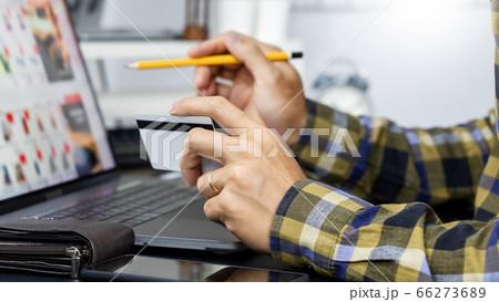 Asian man holding credit card to Online shopping 66273689