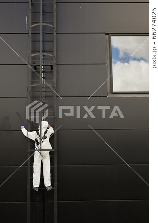 Abstract Background of Worker Disinfecting Black Facade 66274025
