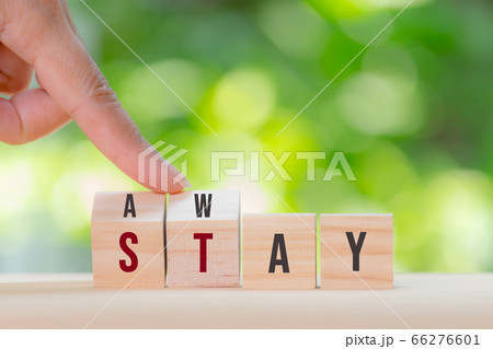Woman hand turned wooden cube to changes the words AWAY to STAY.Stay at home, Stop covid-19 outbreak Woman hand turned wooden cube to changes the words AWAY to STAY.Stay at home, Stop covid-19 outbreak 66276601