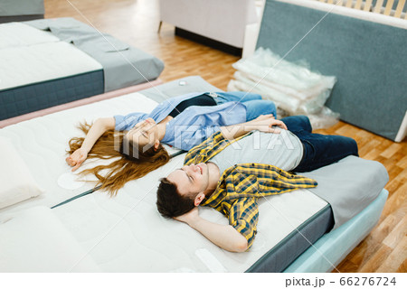 Love couple lying in bed, furniture store showroom 66276724