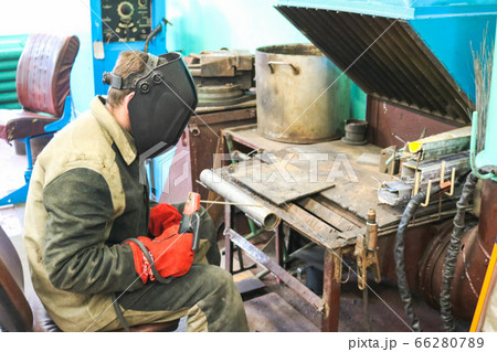 A male worker a welder in a protective mask 66280789