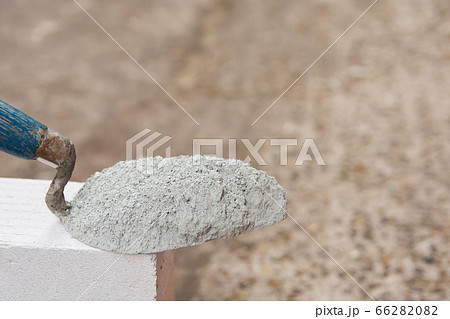 Cement powder or mortar with  trowel put on the 66282082