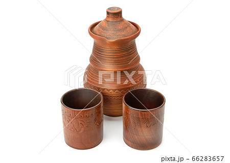 Clay jug and two ceramic glasses isolated on a Clay jug and two ceramic glasses isolated on a 66283657