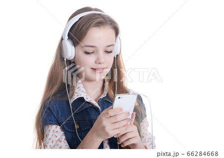 Happy little girl in jeans jacket listening music with smartphone 66284668