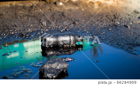 Closeup image of soil polluted with plastic gardage and oil waste. Concept of harm to environment and ecology disaster 66284909
