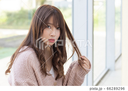 窓際に座るロングスタイルの若い女性 窓際に座るロングスタイルの若い女性 66289296