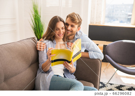 Young woman studying before exam, her husband hugging her and smiling Young woman studying before exam, her husband hugging her and smiling 66296082