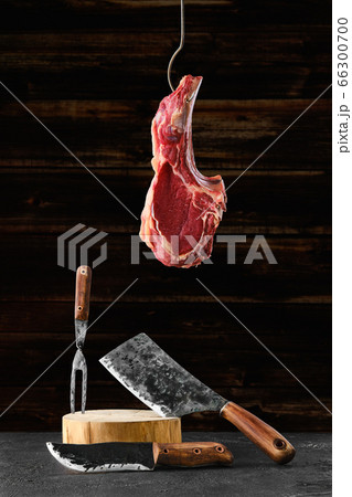 Beef ribeye steak bone-in on steel hook over the forged butcher set 66300700