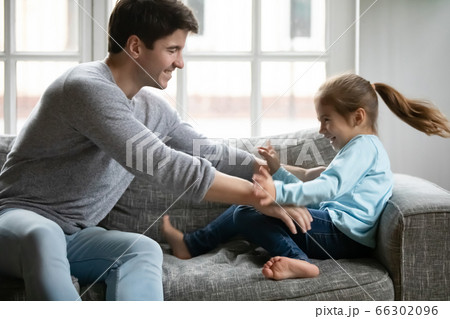 Playful dad have fun playing with small daughter 66302096