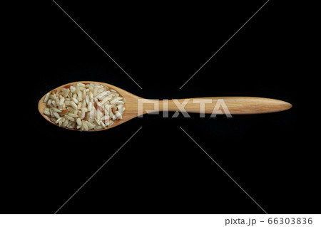 Pile of brown rice with spoon isolated on Black 66303836