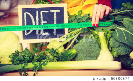 Woman in kitchen having green diet vegetables Woman in kitchen having green diet vegetables 66306374
