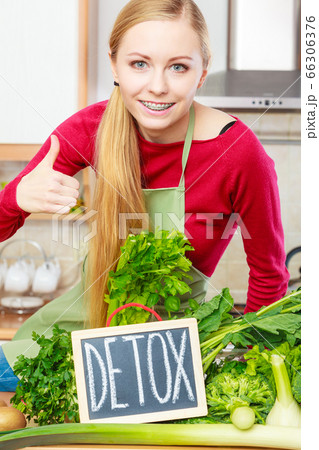 Woman having green diet vegetables, detox sign 66306376