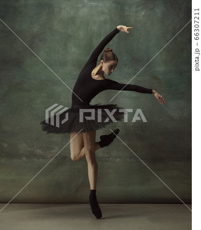 Young graceful tender ballerina on dark studio background 66307211